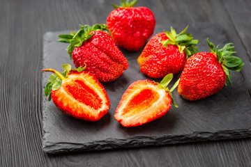 Fresh strawberries on dark background.