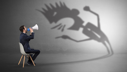Young businessman staying and negotiate with a monster shadow