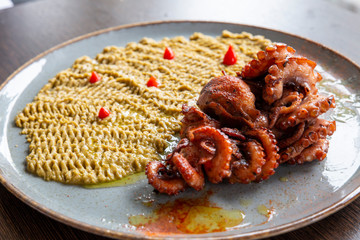 Gourmet plate with cooked octopus and eggplant sauce
