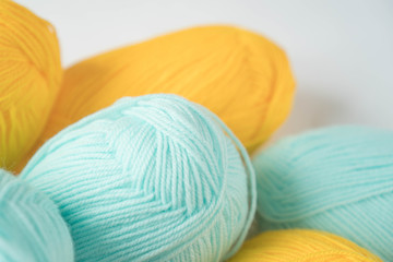 Mint and yellow acrylic yarn on a white background,with copyspace. Beautiful yarn for knitting baby clothes. For yarn, children's clothing store, flyer design, banner, for site