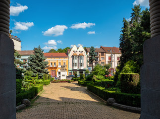 Fototapeta na wymiar Typical colored buildings and houses of Targu Mures, Transylvania, Romania, in front of the city's administrative palace gardens
