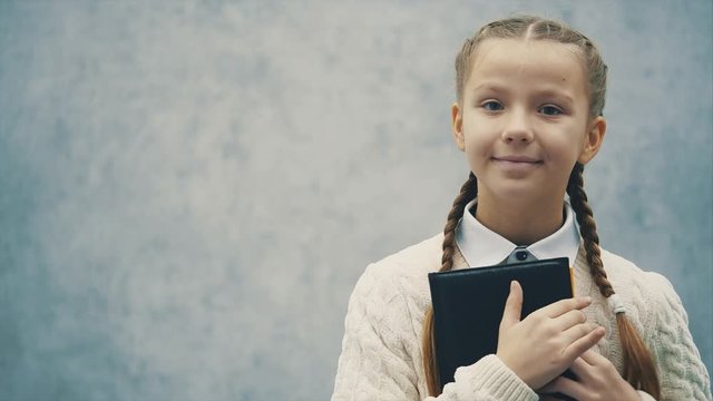 Happy schoolkid loves books so much and strives to new knowledge.