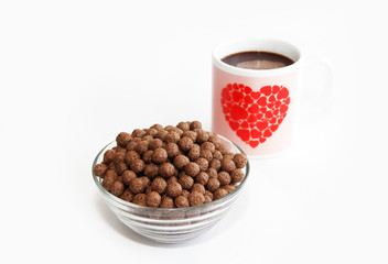 chocolate corn balls in a glass plate and cocoa mug for breakfast