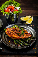Grilled chicken fillet and vegetables on stone plate