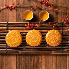 Moon cake Mooncake table setting - Chinese traditional pastry with tea cups on wooden background, Mid-Autumn Festival concept, top view, flat lay.