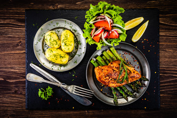 Grilled chicken fillet and vegetables on stone plate