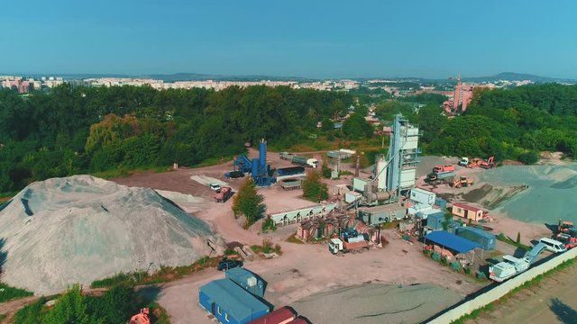 Aerial view of large sand piles and launching of building. 4K.