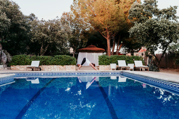 Portrait of young woman (fitness, yoga, healthy body) at the swimming pool. Freedom Concept. Outdoors. Yoga and mindfulness healthy lifestyle