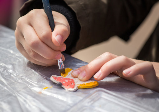 Child painting clay decoration
