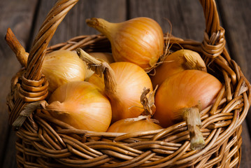 basket of onions on weathered wooden background