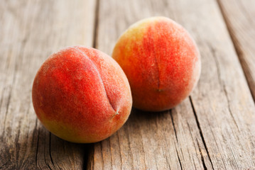 two peach fruits on old weathered wooden table background