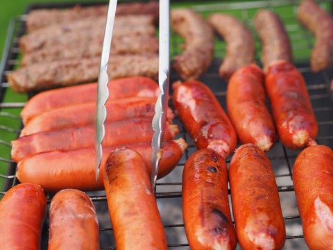 Appetizing and beautiful mix - Hot dogs, sausages, wieners fry and turn the tongs on the grill barbecue. Family picnic  is on Sunday.