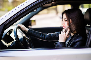 Concept danger driving. Young woman using cell phone while driving car