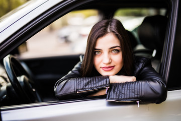 Plakat Beautiful girl in jacket is smiling while driving a car