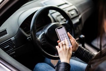 Close up of woman using smartphone while driving car