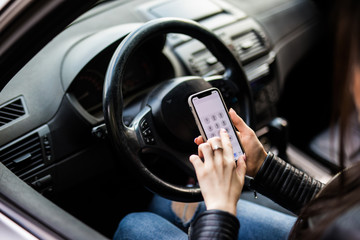 Fototapeta premium Close up of woman using smartphone while driving car