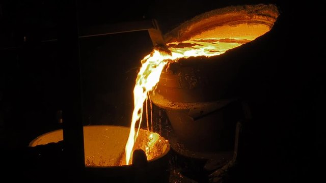 Metal casting steel works. Metallurgy process. Hot steel pouring in steel plant. Smelting of metal in big foundry. Iron and factory workshop