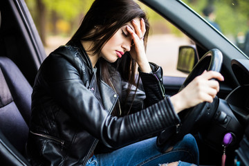 Business woman having headache taking off her glasses has to make a stop after driving car in...