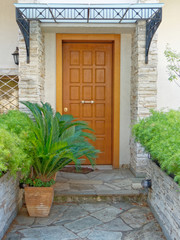 Fototapeta na wymiar contemporary house entrance wooden door and flowerpot