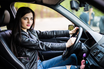 Fototapeta na wymiar Portrait of beautiful young woman in new car, driving her automobile first time, beeps.