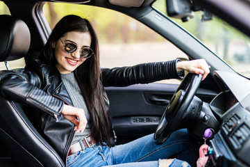 Fototapeta na wymiar Side view of young woman driving a car