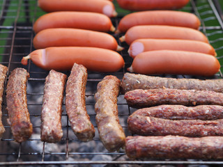 Appetizing and beautiful mix - Hot dogs, sausages, wieners fry and turn the tongs on the grill barbecue. Family picnic  is on Sunday.