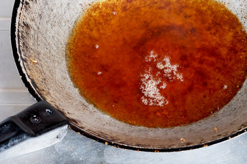 Old used cooking oil in dirty iron pan on a stove and space for write wording, dangerous cooking lifestyle of reusing old used oil that may contain many carcinogens cause of cancer and other diseases