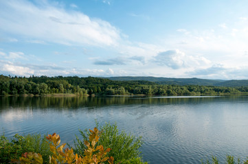Naklejka premium beautiful summer lake against the background of high mountains and blue sky