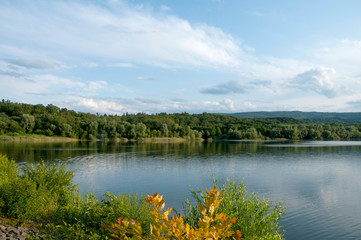 Fototapeta na wymiar beautiful summer lake against the background of high mountains and blue sky