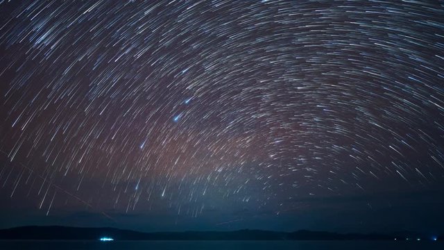 Time-Lapse startrails on a dark sky , nightscape near seascape , Zoom out.