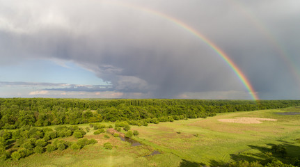 Landscape of plains with two rainbows on sky
