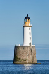 Fototapeta na wymiar Rattray Head Lighthouse just off Rattray Point in Aberdeenshire, Scotland, on one fine Summers Afternoon in calm conditions.