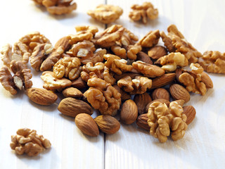 walnuts and almonds on a light wooden surface
