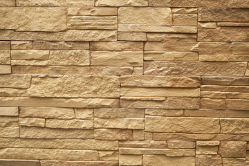 Close up abstract pattern of sandstone brick wall background in vintage tone style and vertical...