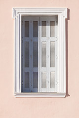 Old window shutters on orange home