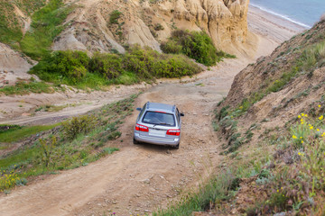 Obraz na płótnie Canvas car goes down the mountain dirt road