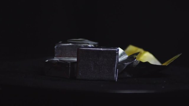 Detail of Bouillon cube rotating on black background. Static. Eye level