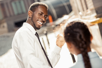 Positive delighted dark-skinned man talking to his kid