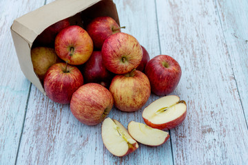 Fototapeta na wymiar Organic ripe apples on a wooden table. Fresh cut apple healthy snack. Cooking ingredients. Harvest.