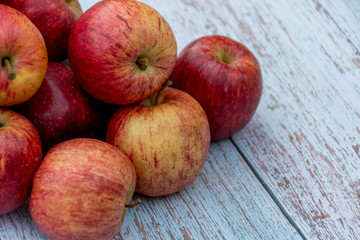 Organic red ripe apples on a wooden table in the garden. Cooking ingredients. Harvest.
