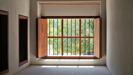 old wooden window in historical fort by sunny outside view