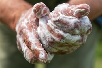 Hand washing with soap outdoors.