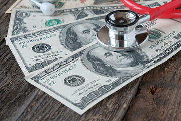 The concept of the cost of medical services, health insurance, a stethoscope on the background of US dollars.