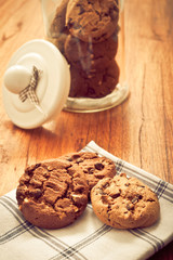 baked chocolate chips cookies biscuits in a glass jar in rustic style 