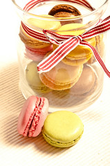 colorful macarons in a  glass jar and decorative ribbon 