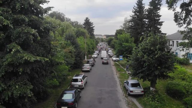 Fly close over a wide road in the village. Flying over the forest and the road. Drone view. Harvest, agriculture concept.