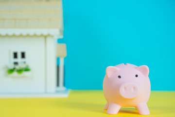 pig money houbox with small house in blue and yellow background