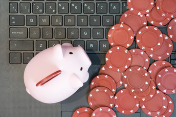 piggy bank with red chips on top of the keyboard
