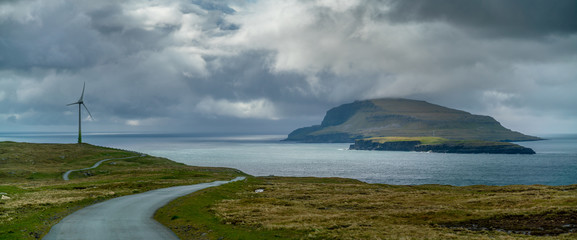 Wind generators near the road with Nolsoy Island view, Faroe Islands