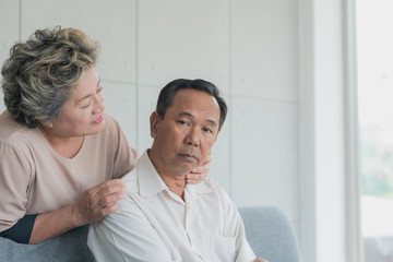 Senior Asian woman feeling sorry and make up for apologies with her husband while he is sulking